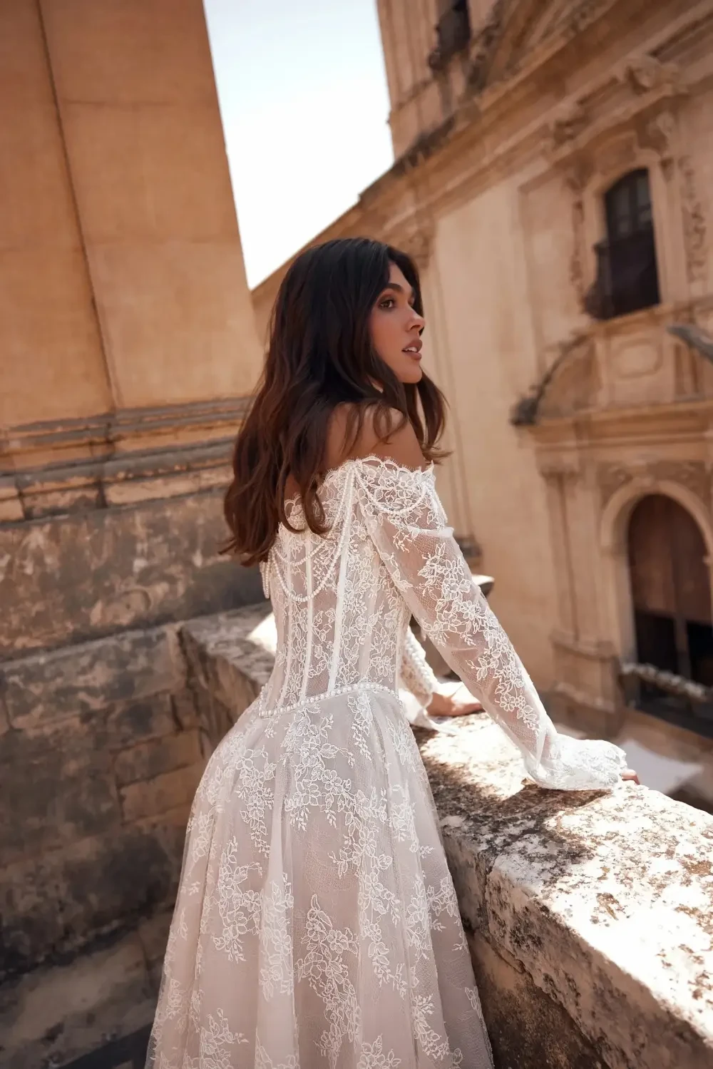 model is wearing an off the shoulder bridal gown