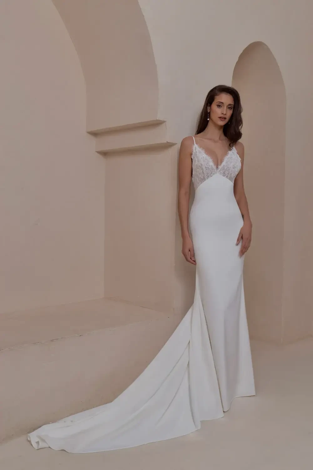 model is wearing a sleeveless sheath bridal gown