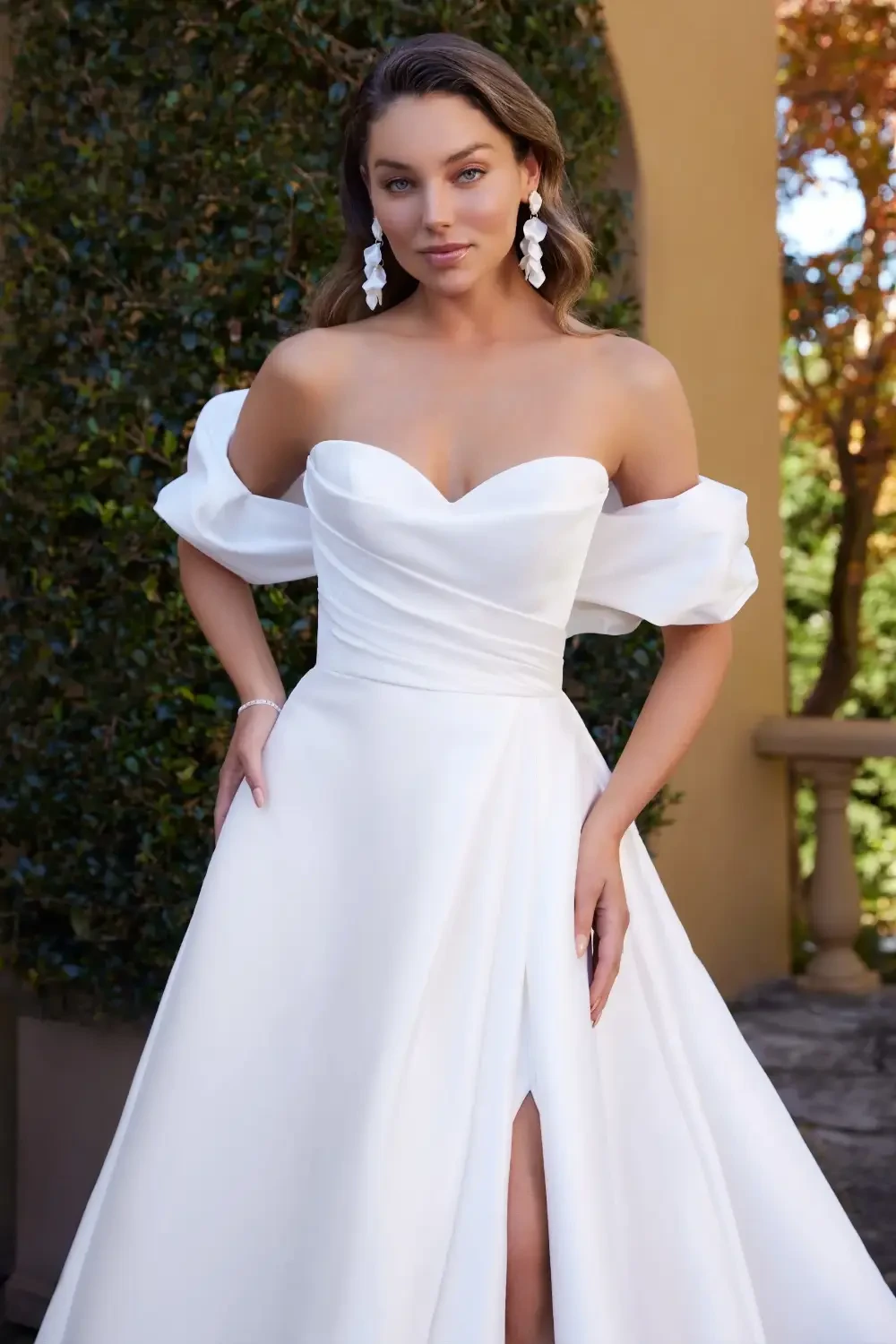 model is wearing an off the shoulder bridal gown