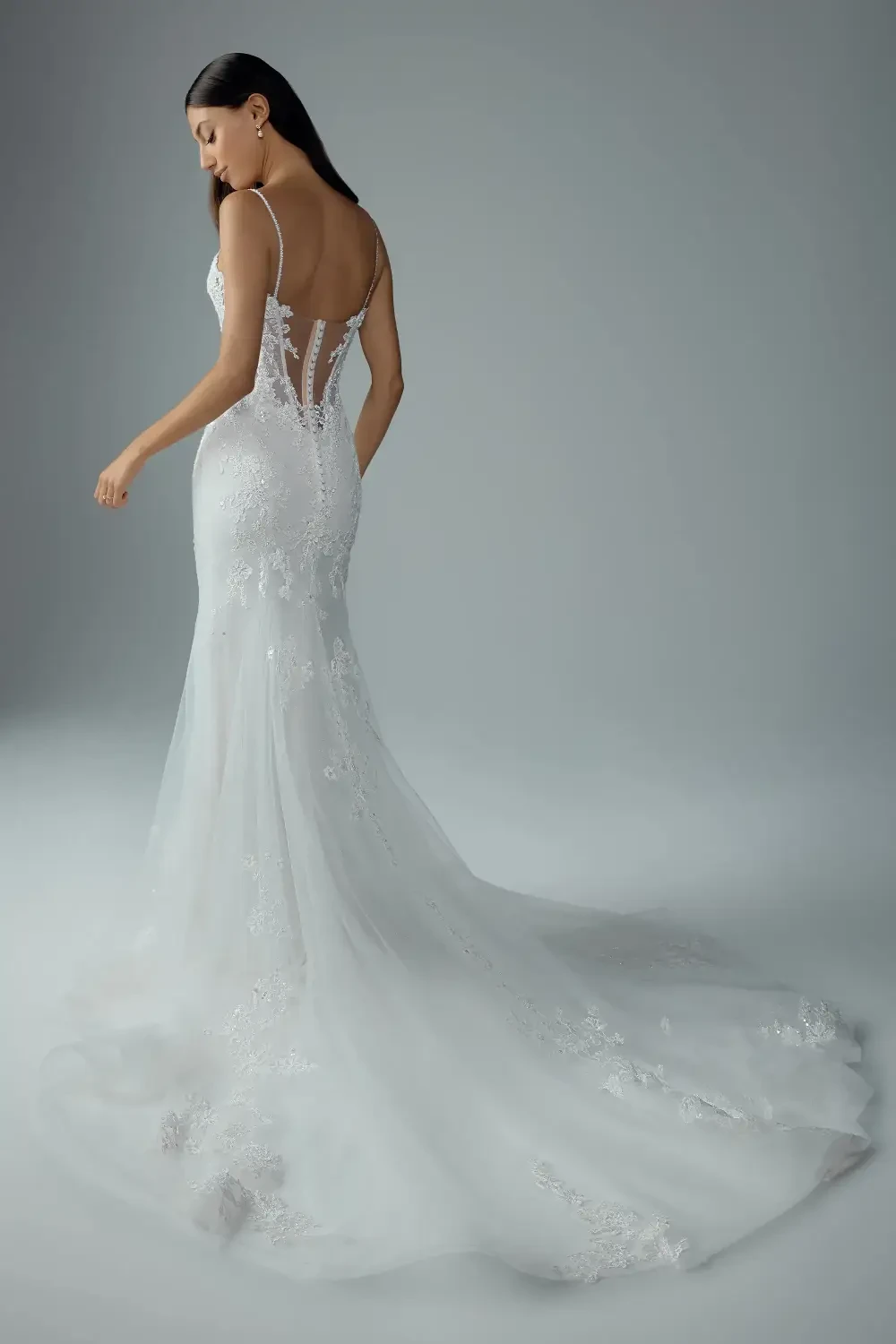 model is wearing an open back sheath bridal gown